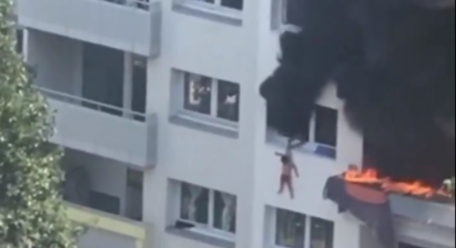 مشهد مثير لحظة رمي طفل لشقيقه من النافذة للنجاة من الحريق